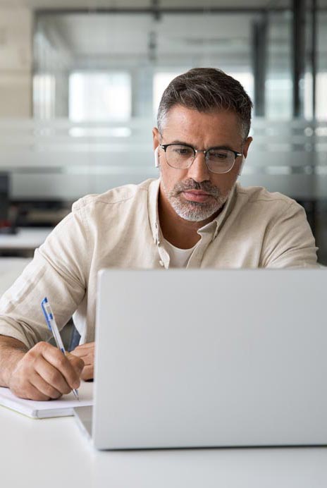 Man Writing Note At Laptop